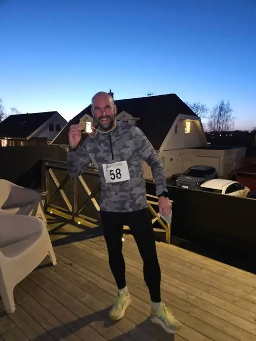 HackaDittLivLoppet 2025 Backyard Ultra - Deltagare håller medalj i skymningen